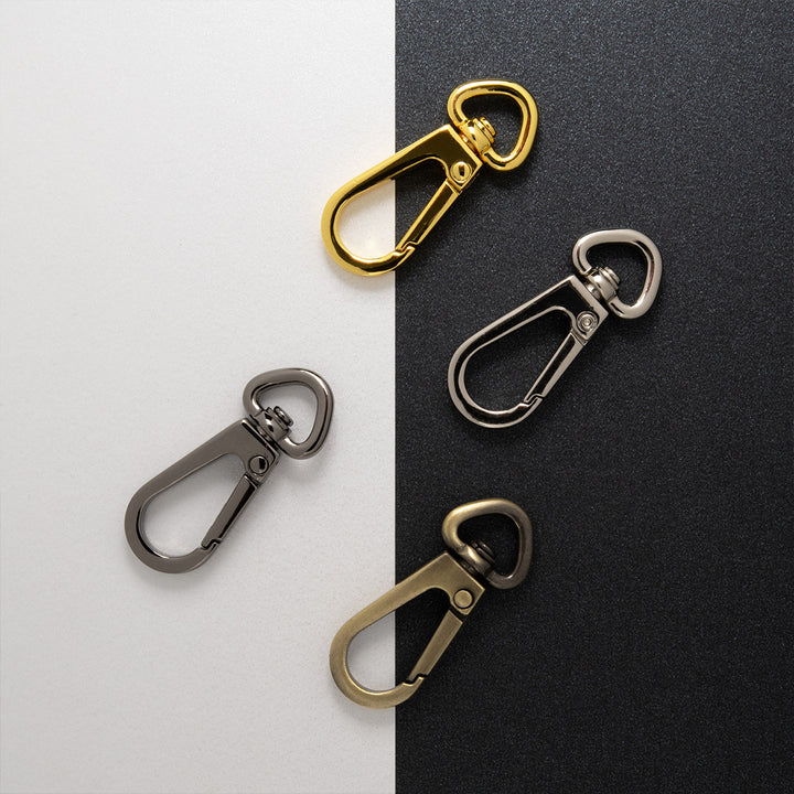 Four metal carabiners in different colors on a two-tone background