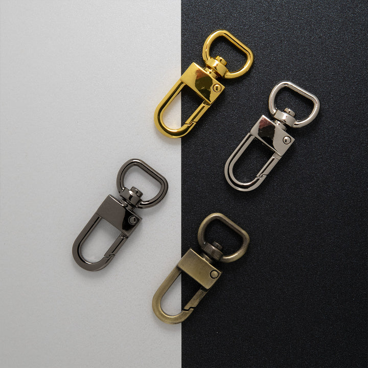 Four metal keychain clasps on a black and white background