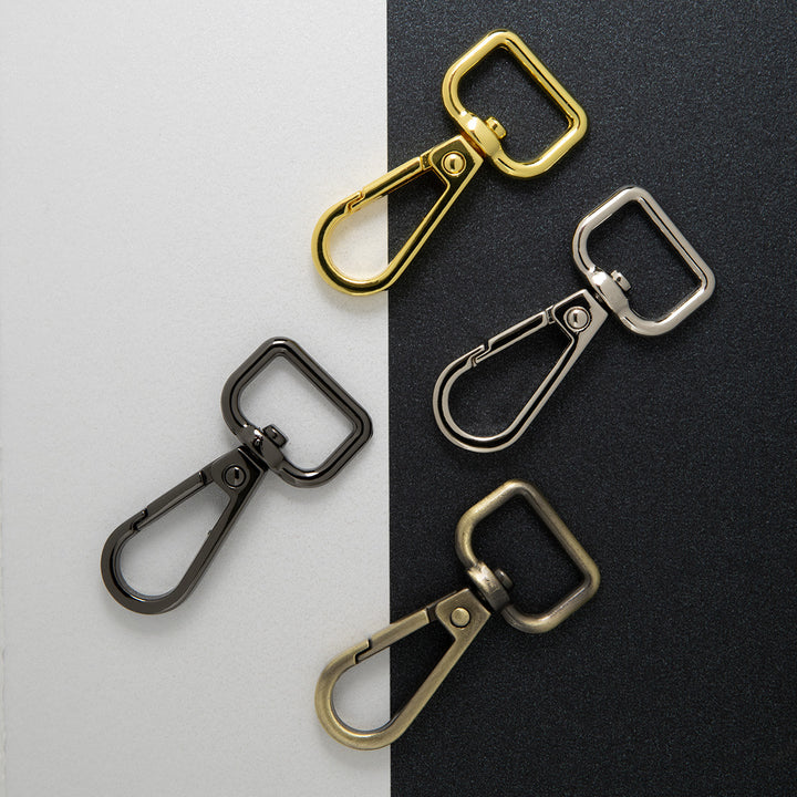 Four dog clips, gild, nickel, antique brass and gun metal on two tone background